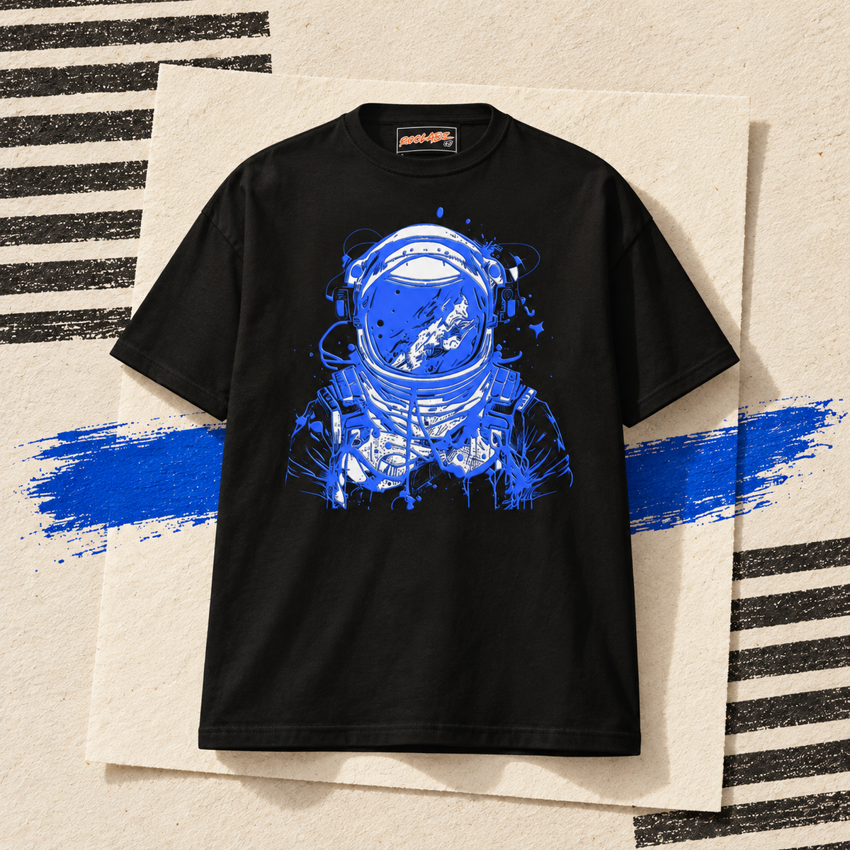 Black RooLabz graphic T-shirt with a blue and white astronaut print on an ivory paper collage.