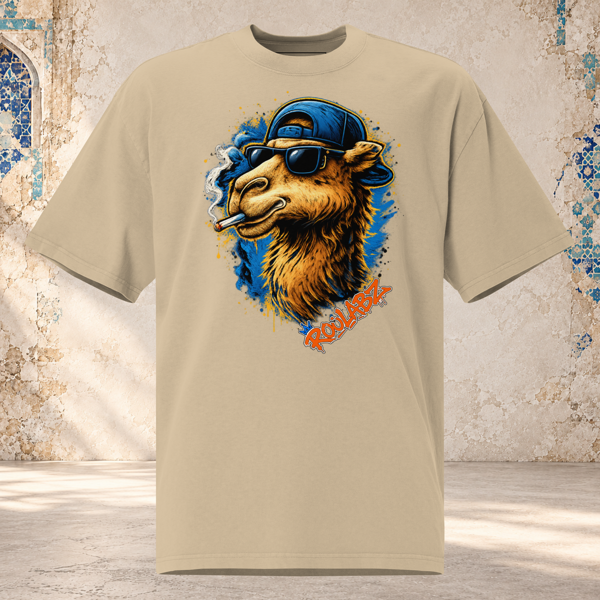 Boxy faded khaki oversized tee with dropped shoulders and a golden camel graphic in sunglasses and a blue cap