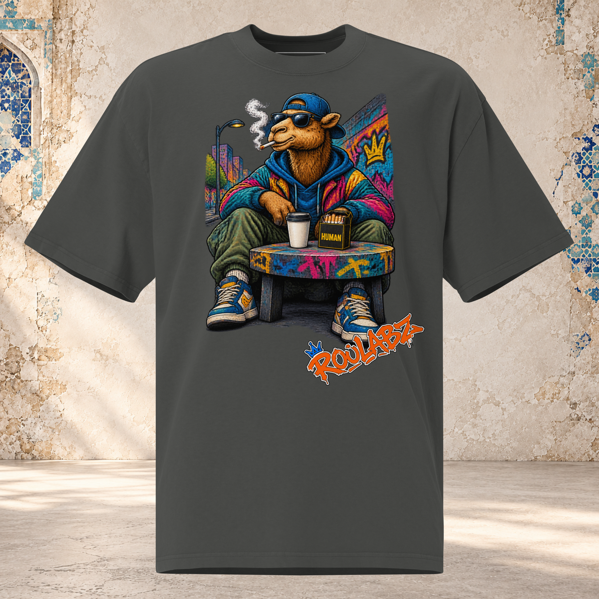 Front mockup of a faded coal oversized tee with a camel in sunglasses and a blue cap seated on a graffiti-covered chair