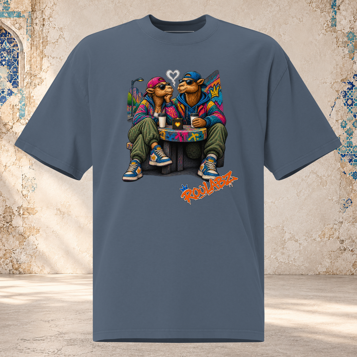 Front mockup of a faded indigo Camel Date oversized tee with two camel characters seated together beside drinks