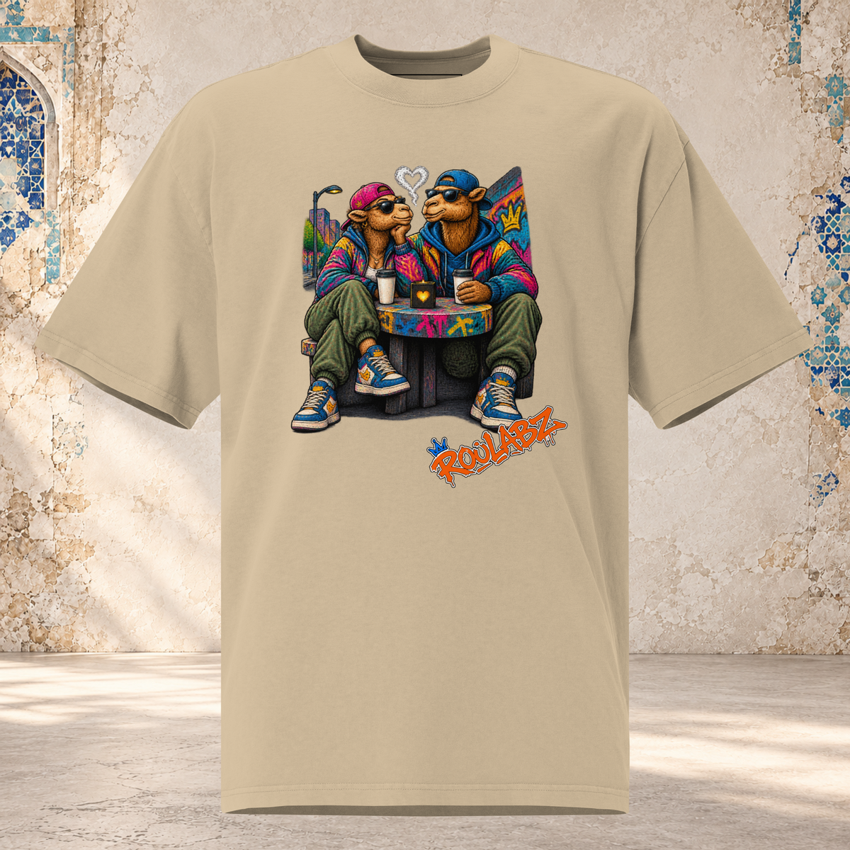 Front mockup of a faded khaki Camel Date oversized tee with two camel characters seated together beside drinks