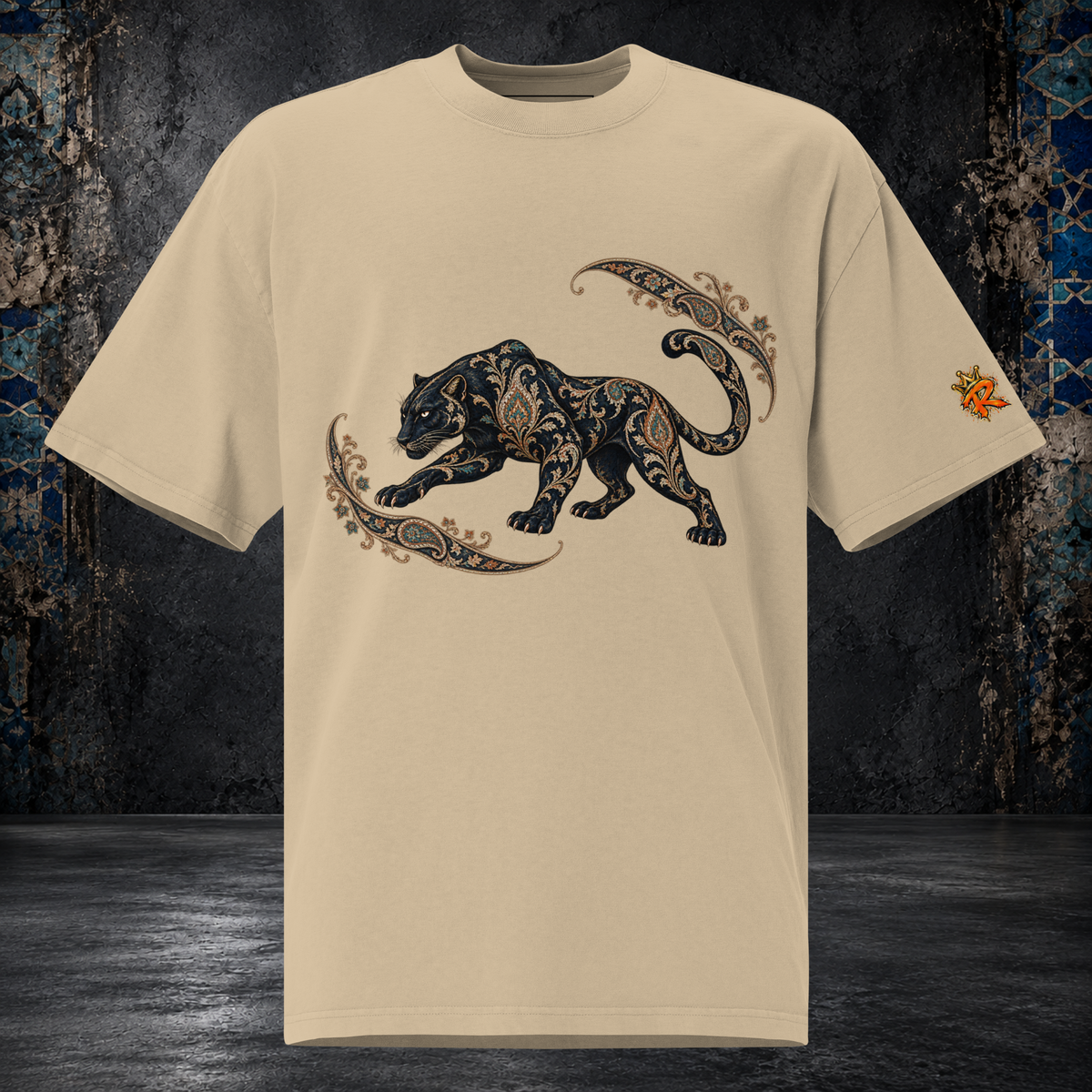 Front mockup of a faded khaki oversized tee with a black panther, gold-toned ornament and curling paisley flourishes