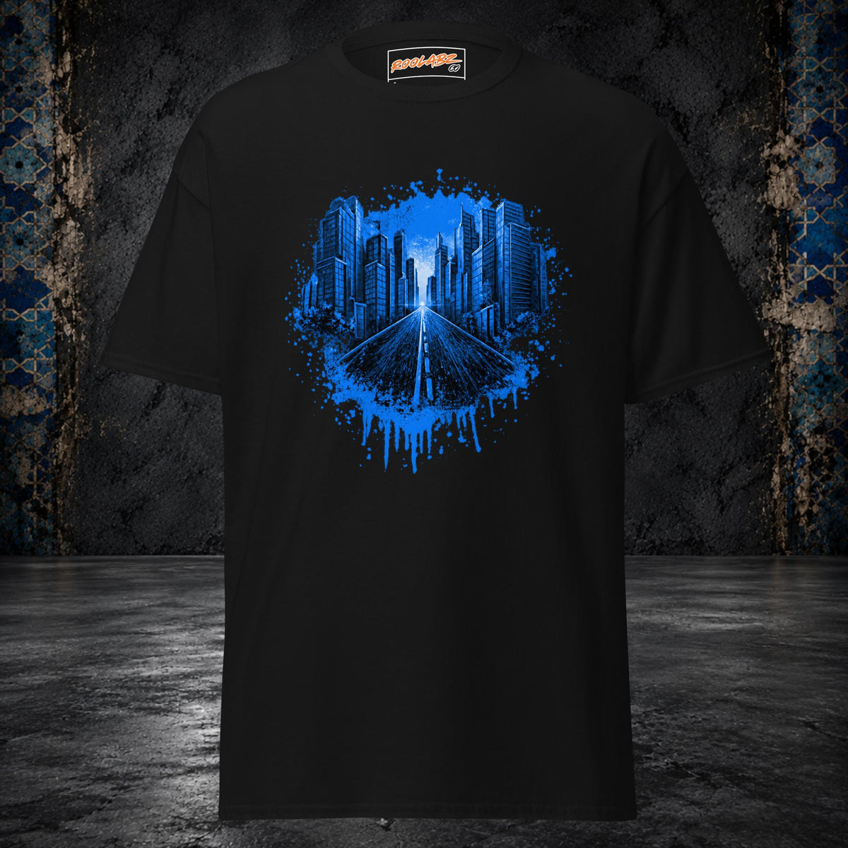Front mockup of a black tee with an electric-blue skyline and highway framed by paint splashes and drips