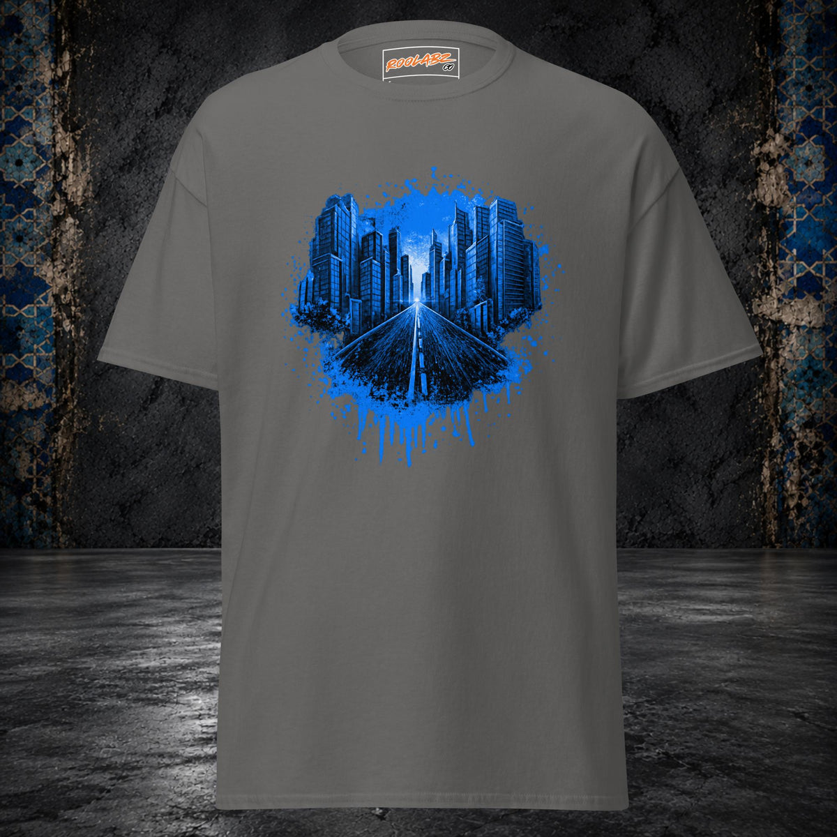 Front mockup of a charcoal tee with an electric-blue skyline and highway framed by paint splashes and drips