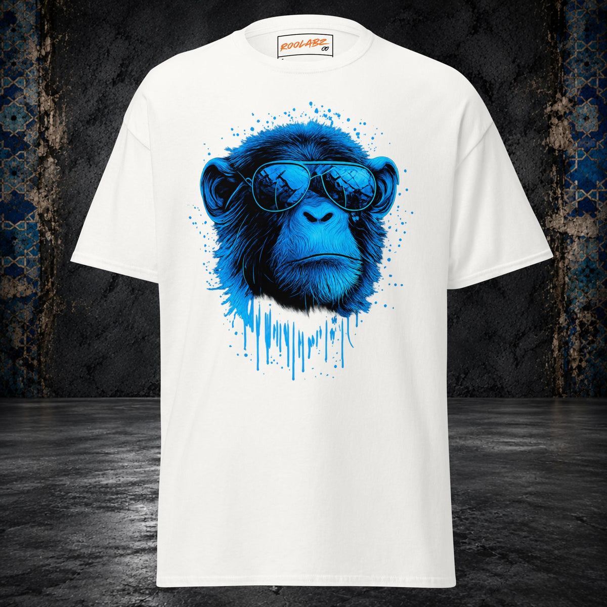 Front mockup of a white tee with a blue monkey portrait in sunglasses framed by ink splashes and drips
