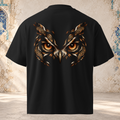 Back view of a black oversized tee with an owl's amber eyes framed by copper feathers and paisley shapes