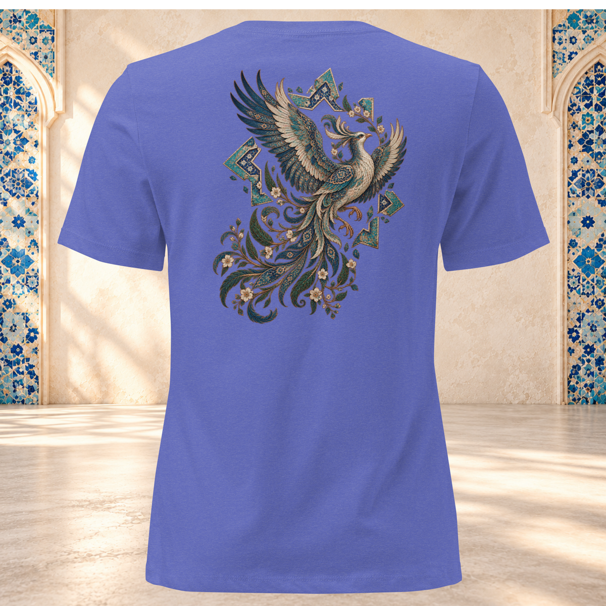 Back mockup of a heather true royal women's tee with an ornate Persian phoenix, raised wings and a sweeping teal and gold tail