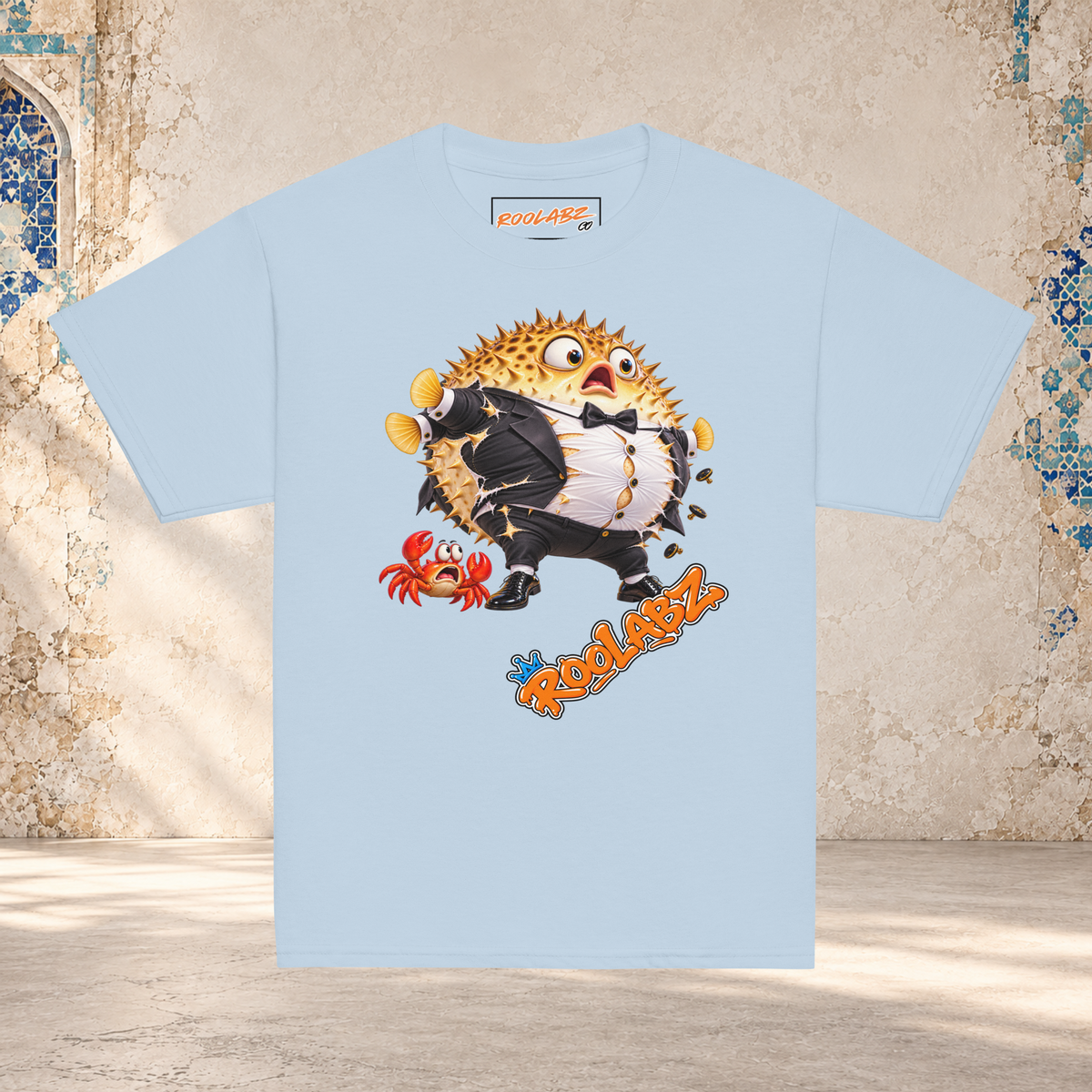 Front mockup of a light blue youth tee with a puffed-up pufferfish bursting out of a black and white tuxedo